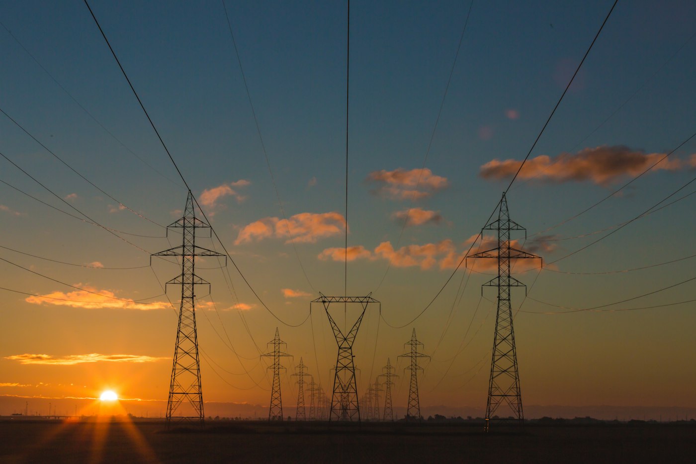 Hoogspanningsmasten bij zonsondergang